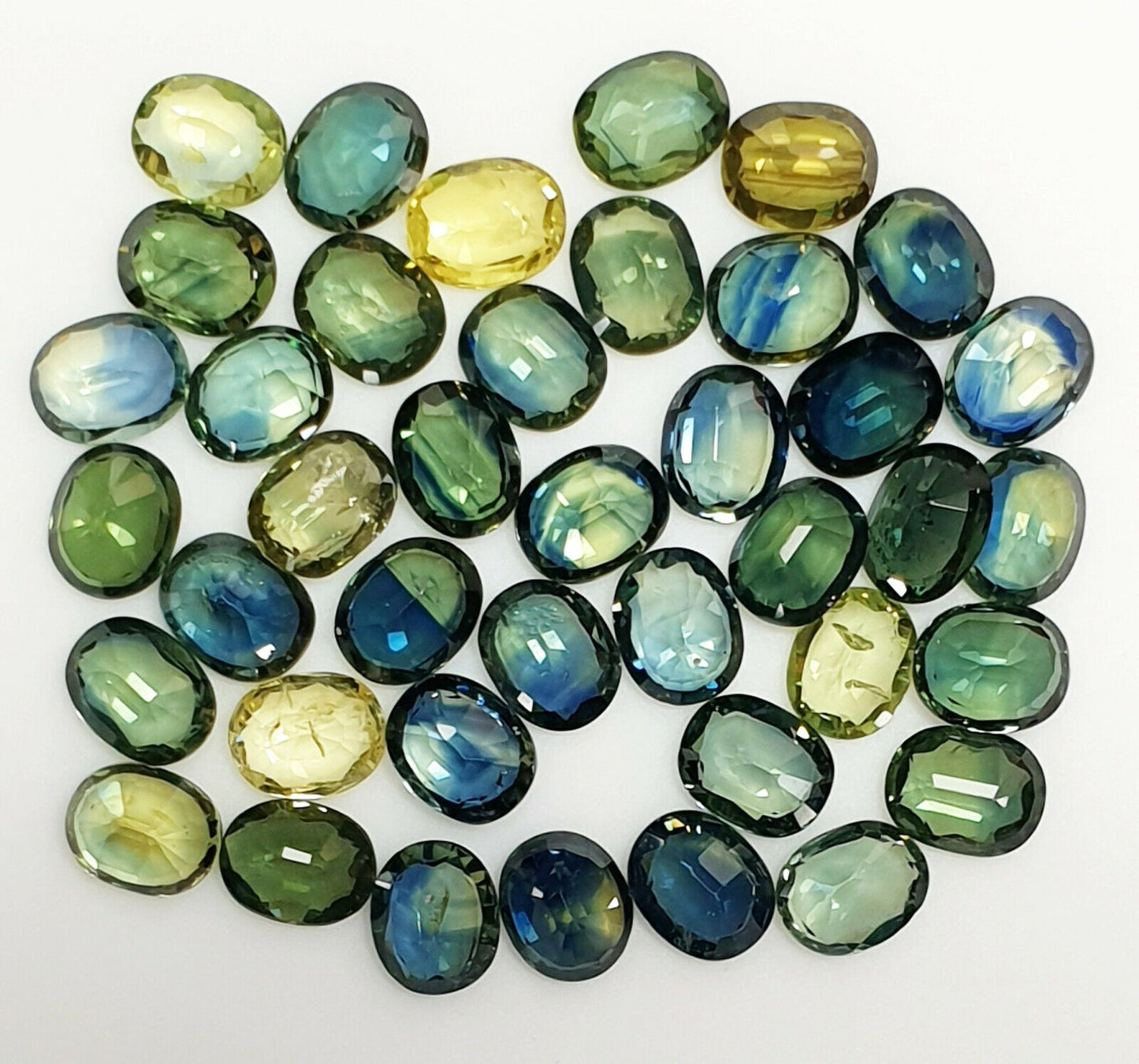 52219 - 40 Oval Cut Aussie Teal, Green, Yellow, Parti Color Sapphires 19.47 cts
