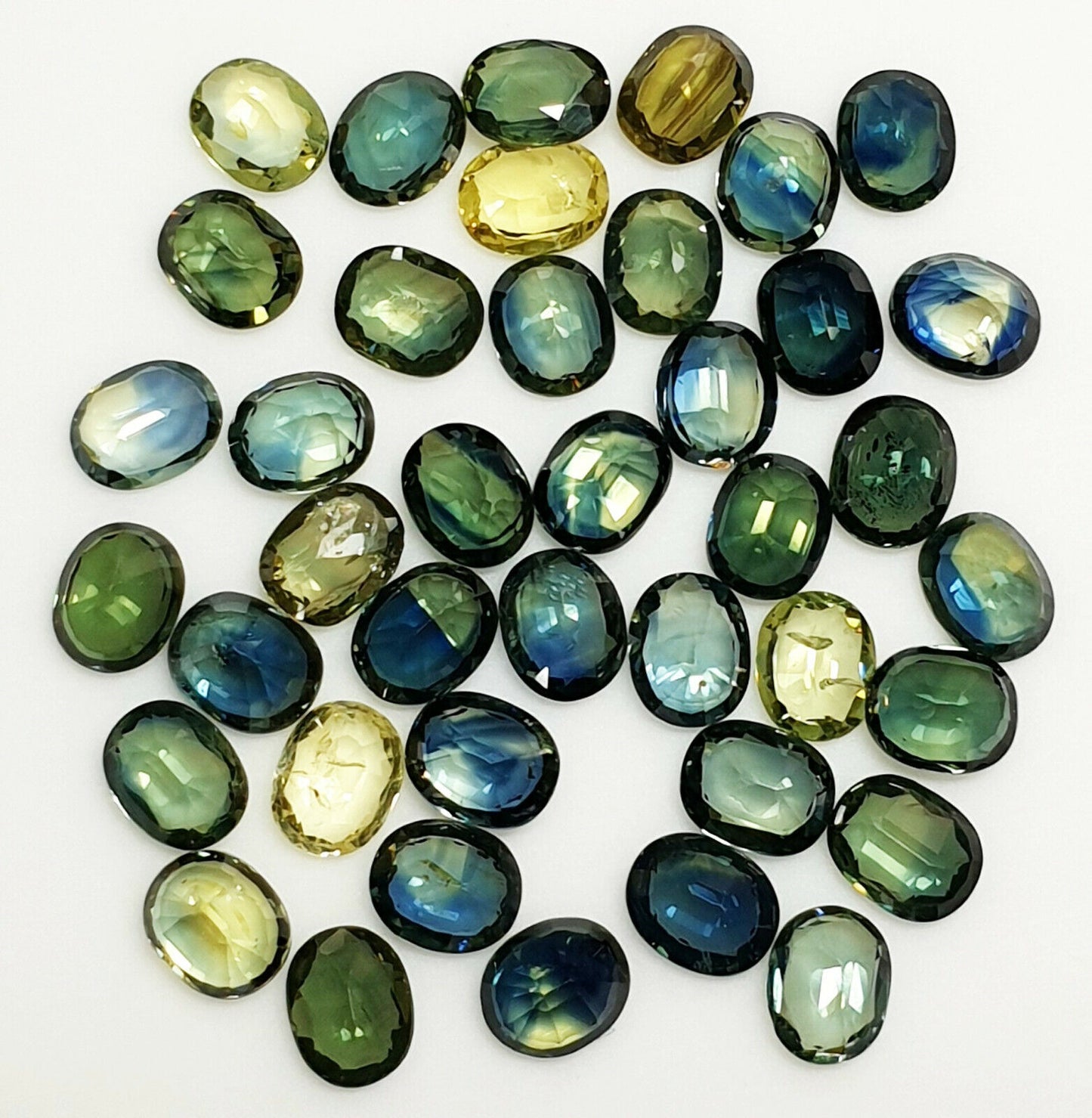 52219 - 40 Oval Cut Aussie Teal, Green, Yellow, Parti Color Sapphires 19.47 cts