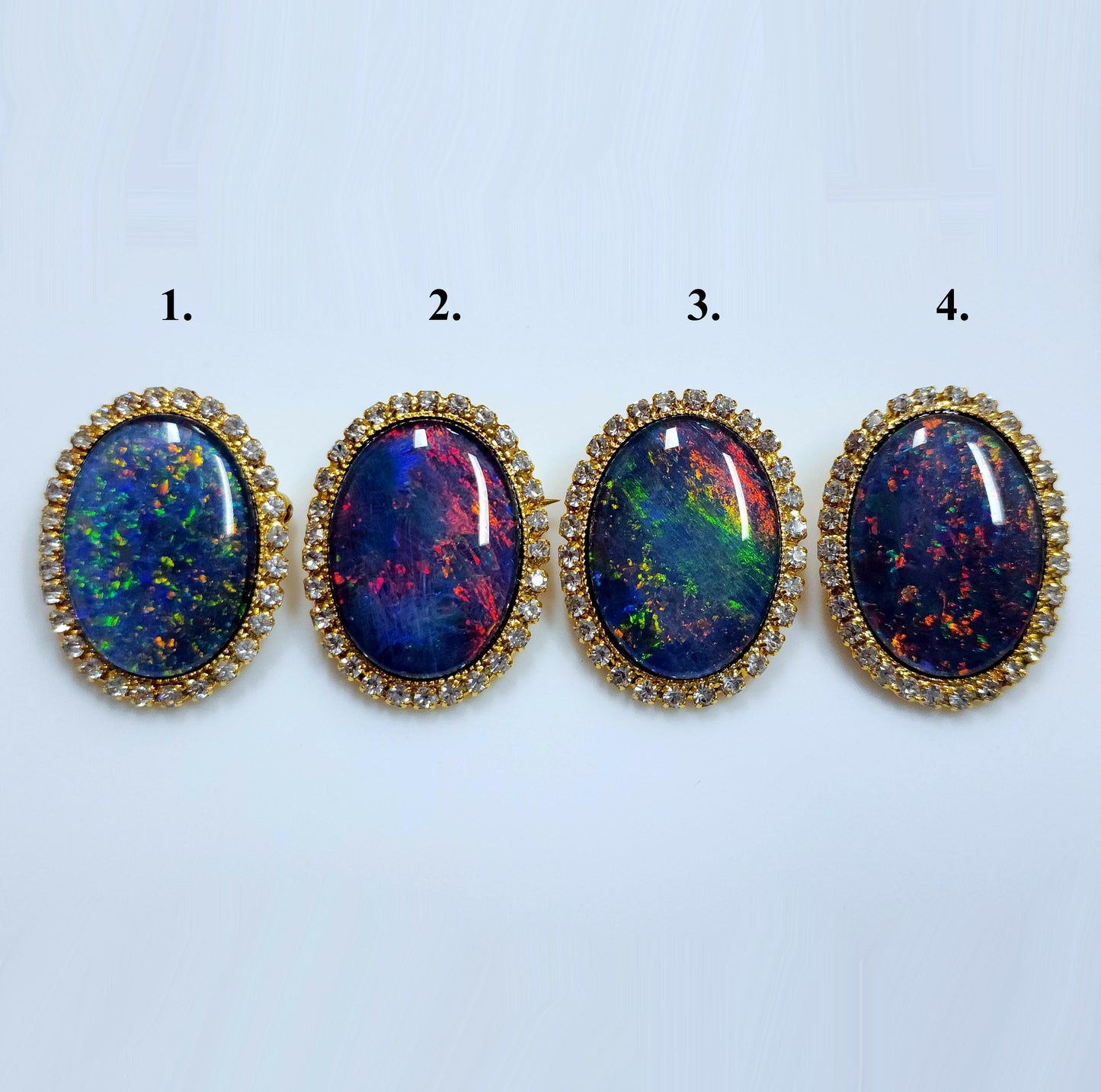 53662.0 - Gullfarget brosje sett med Swarovski-rhinestones som omgir en stor høykvalitets 25 x 18 mm ovalskåret australsk opaltriplett