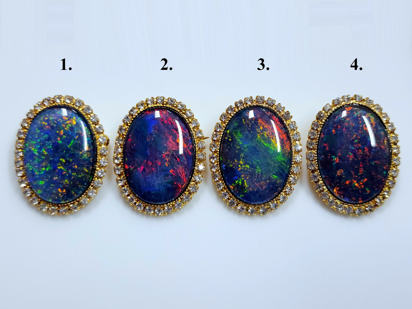 53662.0 - Gullfarget brosje sett med Swarovski-rhinestones som omgir en stor høykvalitets 25 x 18 mm ovalskåret australsk opaltriplett