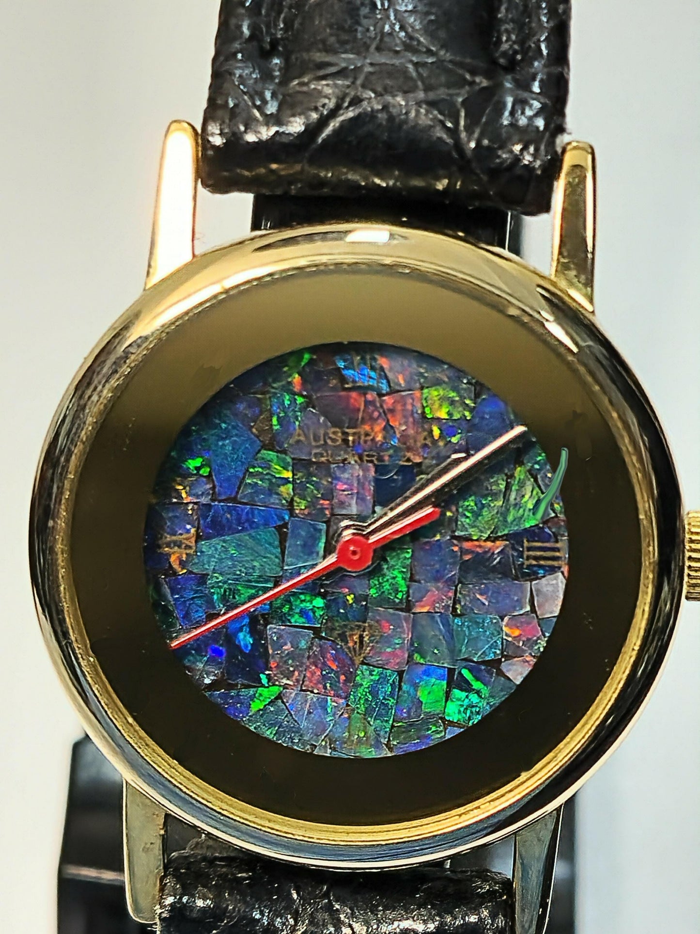 54181.0 - "Australia" Opal Watch with Natural Australian Opal Gold rim with no numbers Black leather strap Japanese movement Water resistant
