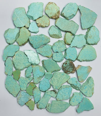 Collection of turquoise stone chips on a white background