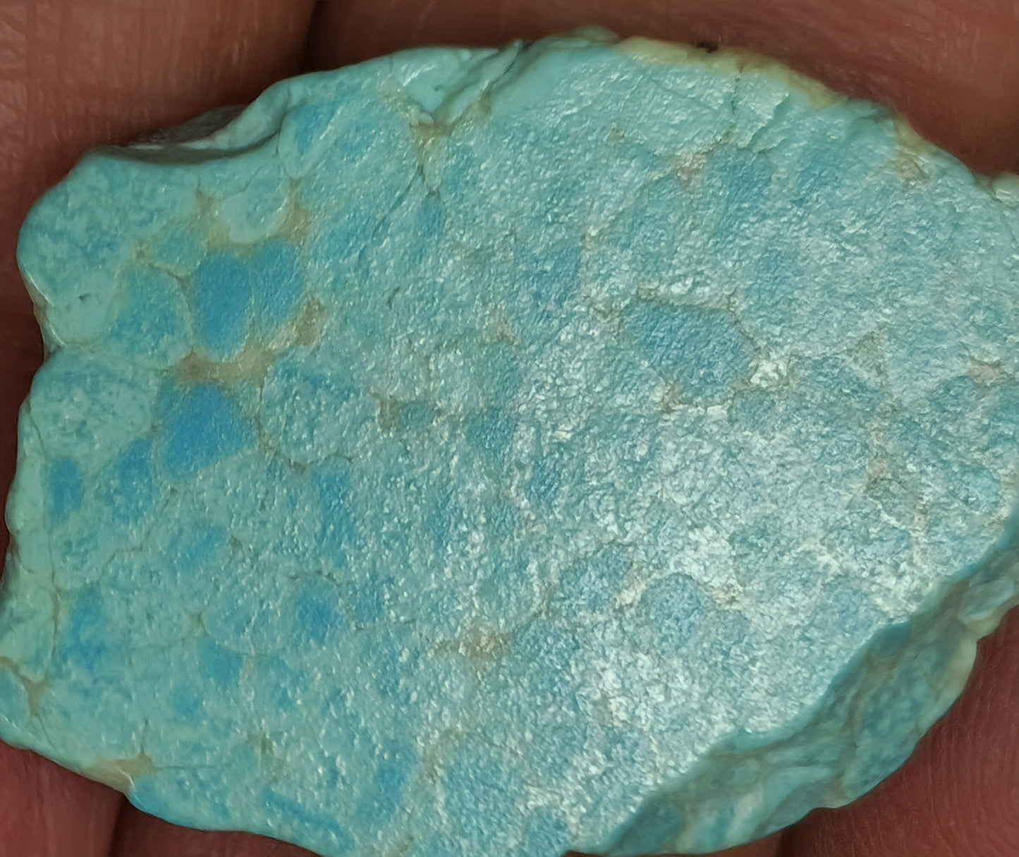 Turquoise stone held between fingers