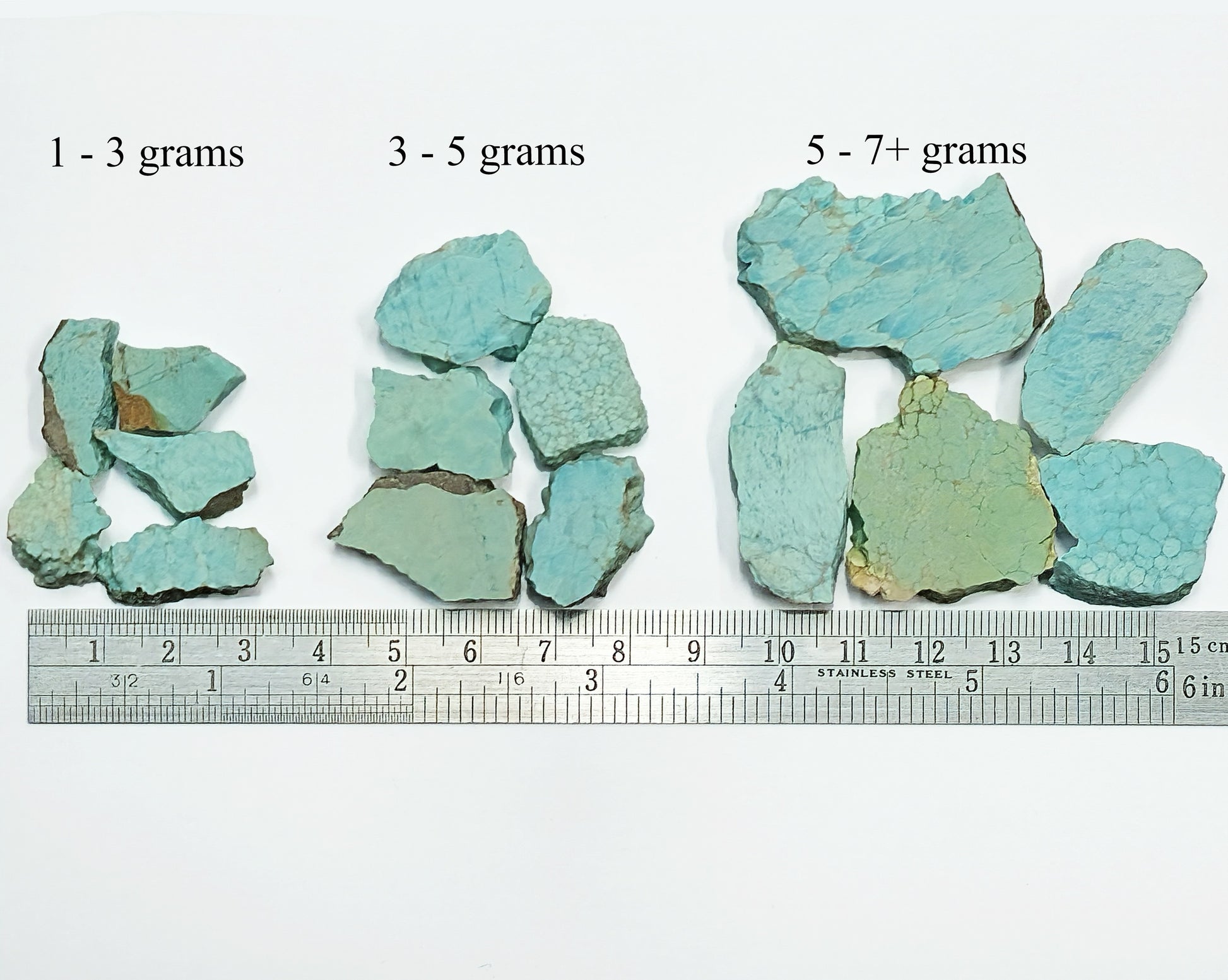 Turquoise stone samples with labeled weight ranges and a ruler for scale.
