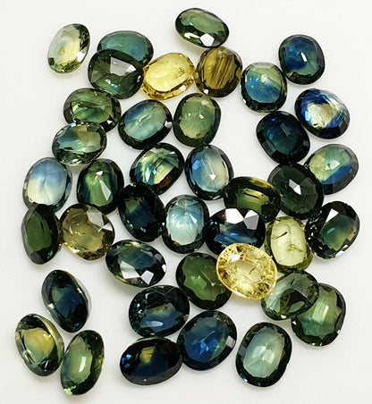 52219 -  40 Oval Cut Aussie Teal, Green, Yellow, Parti Color Sapphires 19.47 cts