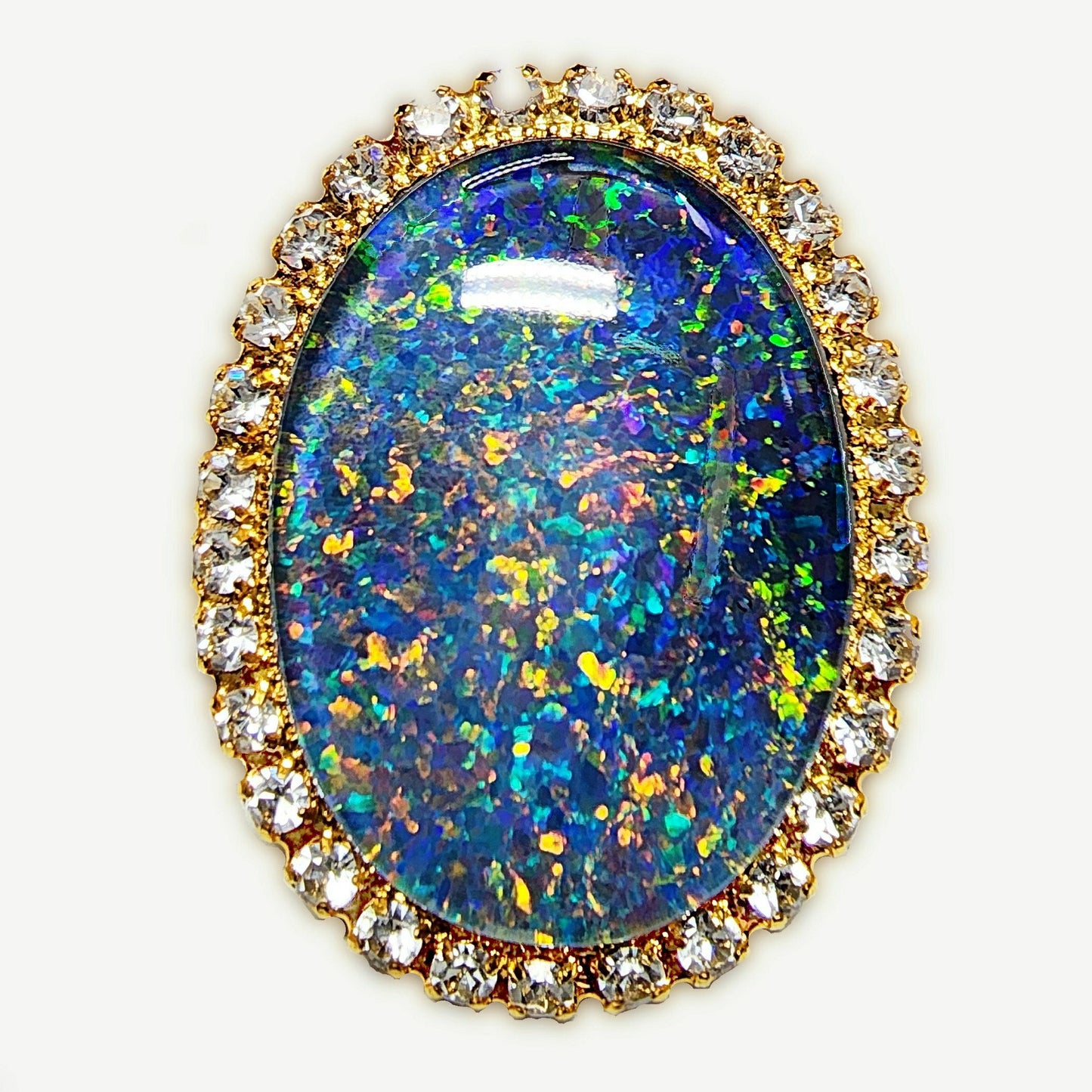 53662.0 - Gullfarget brosje sett med Swarovski-rhinestones som omgir en stor høykvalitets 25 x 18 mm ovalskåret australsk opaltriplett