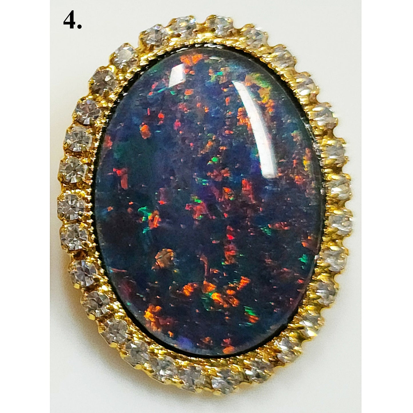 53662.0 - Gullfarget brosje sett med Swarovski-rhinestones som omgir en stor høykvalitets 25 x 18 mm ovalskåret australsk opaltriplett