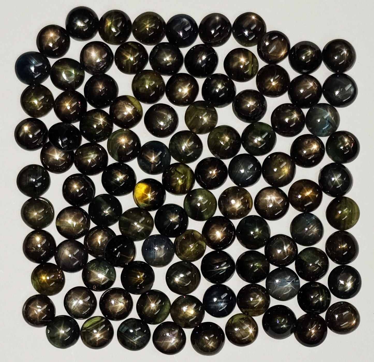 54146.0 - Omtrent 6 mm rundkuttet australske stjerne eller blanke safirer i BLANDE farger inkludert gråaktig, gulaktig, brunaktig og svartaktig.